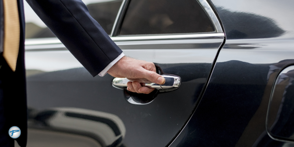 Professional driver in a suit opening the door of a luxury car, representing Charlotte airport transfers and premium car service for travelers.