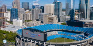 Aerial view of Bank of America Stadium in Charlotte, North Carolina, home of the Carolina Panthers, with the city skyline in the background, highlighting Carolina Panthers game day transportation options.