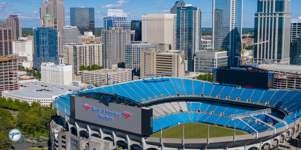 Aerial view of Bank of America Stadium in Charlotte, North Carolina, home of the Carolina Panthers, with the city skyline in the background, highlighting Carolina Panthers game day transportation options.