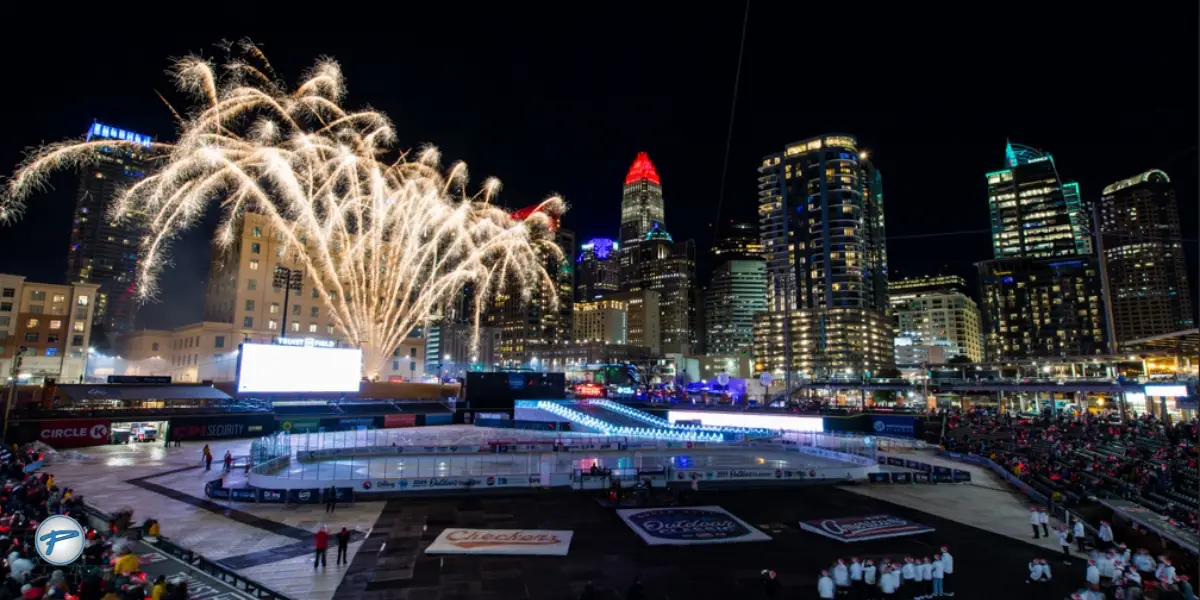 Fireworks light up the night sky over a bustling cityscape during the Charlotte New Year's Eve celebration, with crowds gathered around. The festive atmosphere highlights the importance of New Years Eve transportation and NYE transportation for connecting attendees to urban events.