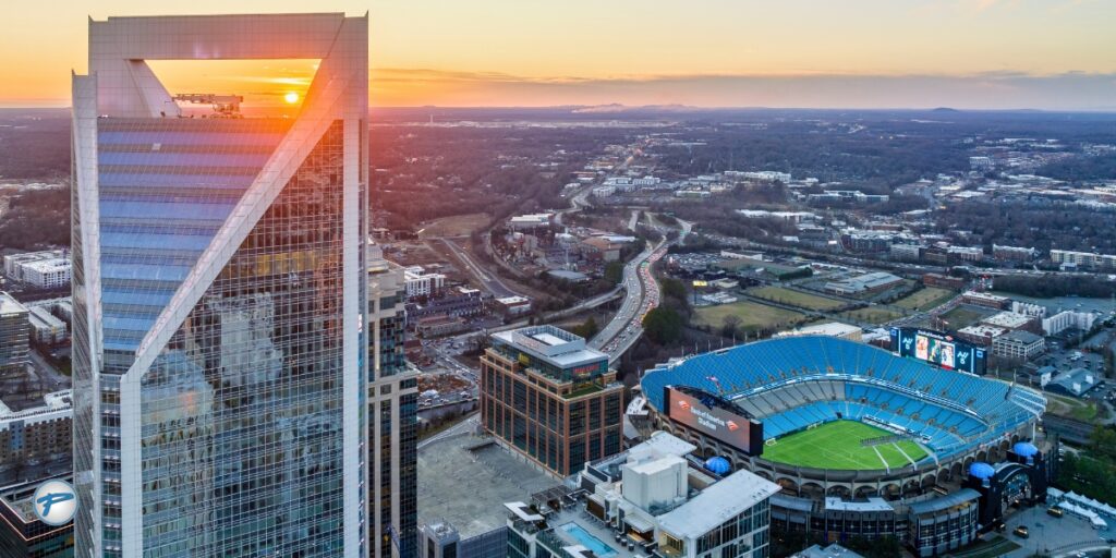 Aerial view of downtown Charlotte at sunset featuring Bank of America Stadium, home to major sports events. Peak Limo offers luxury game transportation, stadium transportation, and sports event transportation with a trusted Charlotte limo service.
