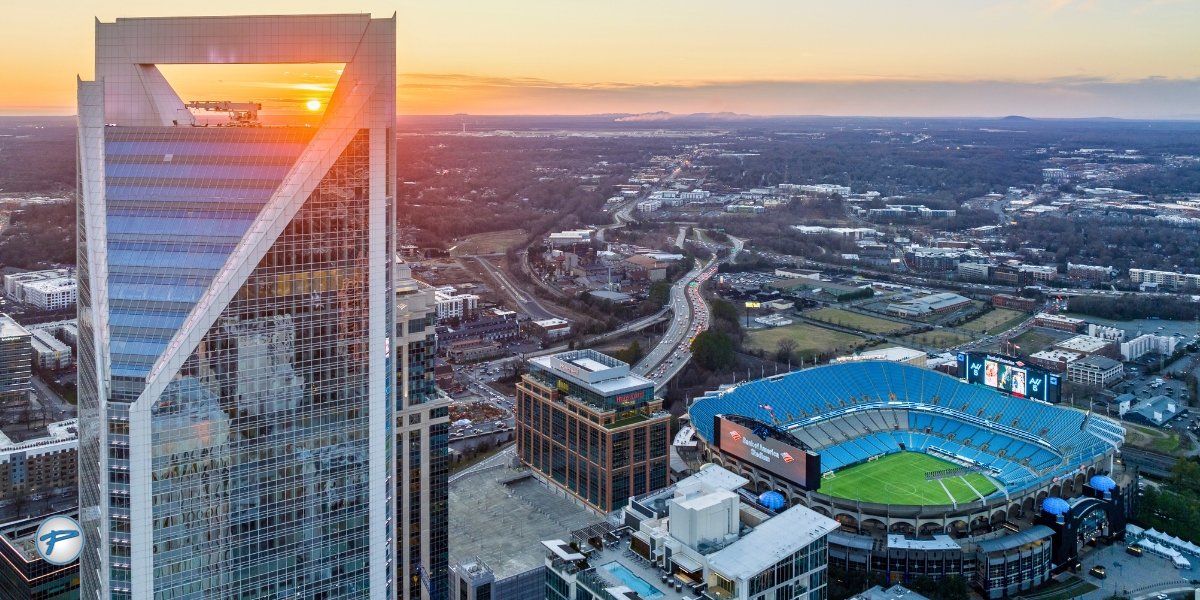 Aerial view of downtown Charlotte at sunset featuring Bank of America Stadium, home to major sports events. Peak Limo offers luxury game transportation, stadium transportation, and sports event transportation with a trusted Charlotte limo service.