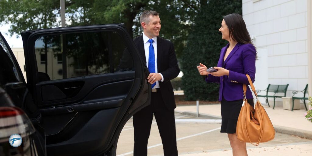 Chauffeur assisting businesswoman into a luxury vehicle, representing Peak Limo’s duty of care and commitment to passenger safety and transportation safety.
