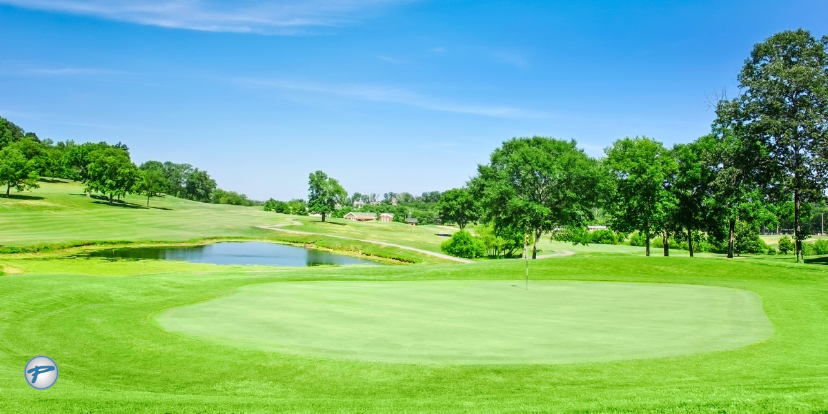 Sunny golf course green with pond and flag at Quail Hollow Club during the Truist Championship