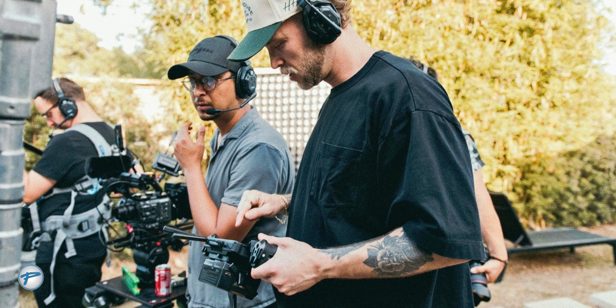 Film crew in headsets reviews a camera monitor on an outdoor movie set, where film production transportation in Charlotte keeps cast and crew on schedule.